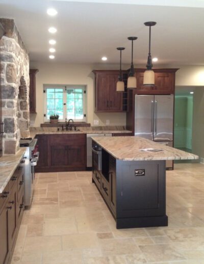 Spacious kitchen with stone accent wall and dark wood cabinets.
